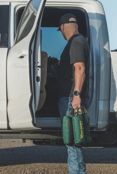 Person holding TackDriver Gun Bag With One Piece Construction And Non Marring Surface For Outdoor Range And Hunting near vehicle