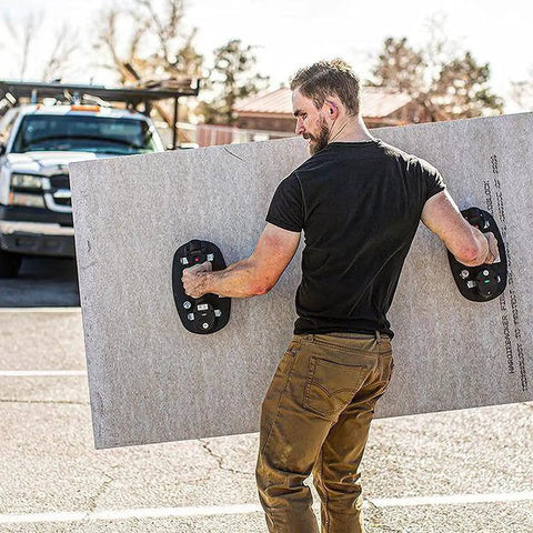 Man using Portable Electric Vacuum Suction Cup Lifter For Wood Tile Marble Drywall Heavy Duty Hand Tool to carry large drywall sheet.