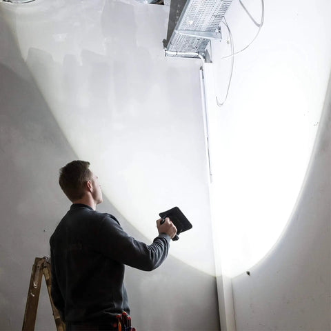 Person using Rechargeable COB LED Floodlight Handheld Beast 2000 Lumen Ultra Slim Work Light to illuminate a ceiling.