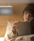 Headboard Reading Lamp With Linen Woven Grey Shade, Sleek Modern Design, Fits Headboards Up To 4 Inches Thick, person reading