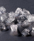 Heavy-Duty Commercial Nugget Ice Maker ice cubes scattered on a dark surface, showcasing chewable transparent nuggets.