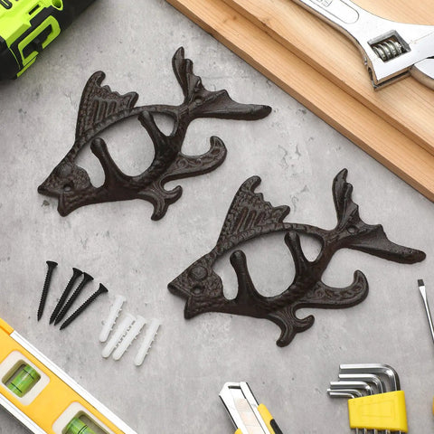Dead Reliable Cast Iron Fish Wall Hooks 2 Pack, matte brown fish coat hangers on table with tools.