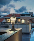 Two Pack 17 Inch Outdoor Post Light Fixtures With Motion Sensor And Dusk To Dawn on modern rooftop, glowing at dusk.