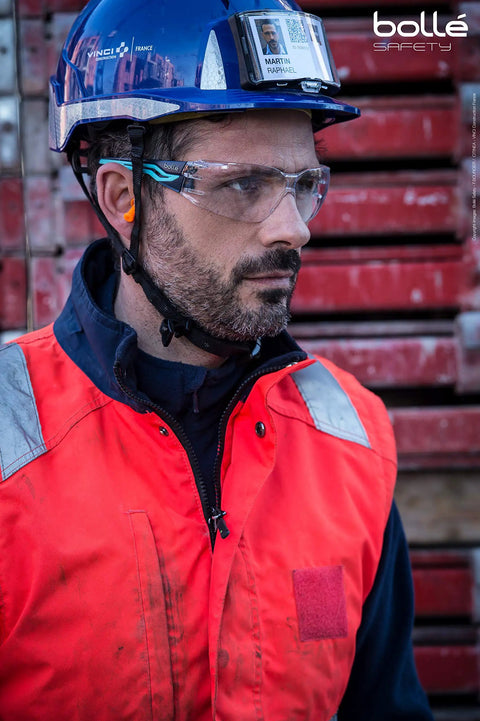 Worker wearing Silex Safety Glasses With Anti Scratch Anti Fog Coating Black Blue Frame Clear Lenses at construction site.