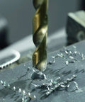Close-up of 21 Piece Cobalt M42 Drill Bit Set With Case And Three Flat Shank For Stainless Steel drilling into metal surface