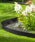 Close-up of a garden with Flexible Plastic Landscape Edging Kit With 120 Metal Spikes, 1.5 Inch High, forming a neat border.