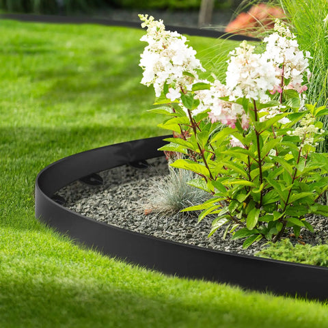 Close-up of a garden with Flexible Plastic Landscape Edging Kit With 120 Metal Spikes, 1.5 Inch High, forming a neat border.