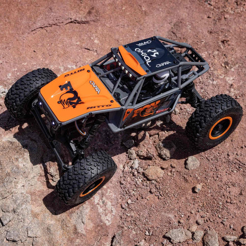 Capra UTB18 One Eighteenth Scale RC Crawler 4WD RTR on rocky terrain, featuring tube chassis and multicolor gray design.