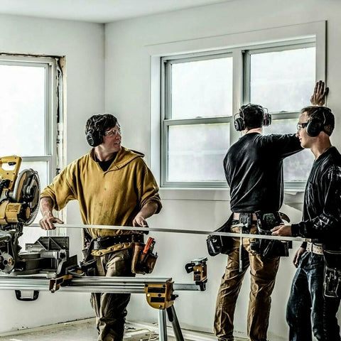Workers using Gel Cushions Bluetooth Hearing Muffs With Active Mic 26 dB NRR on a construction site with power tools.