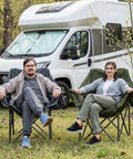 Two Pack Oversized Heavy Duty Camping Chairs Padded And Foldable With Cup Holder And Cooler Bag Portable Lawn Chairs For Sports And Outdoors Supports Up To 450 Lbs Grey with two people seated outdoors.