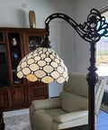 Tiffany Style Arched Floor Lamp With Stained Glass Jeweled Shade, 62 Inch Tall, in cozy living room near armchair