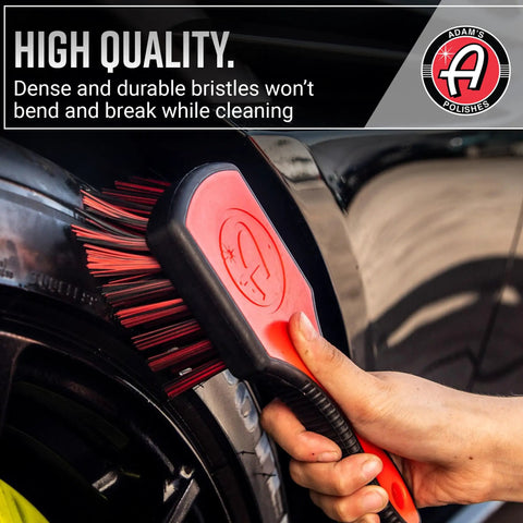 Hand using Premium Tire Brush For Car Detailing And Tire Cleaning With Soft Bristles Rubberized Head And Grippy Handle