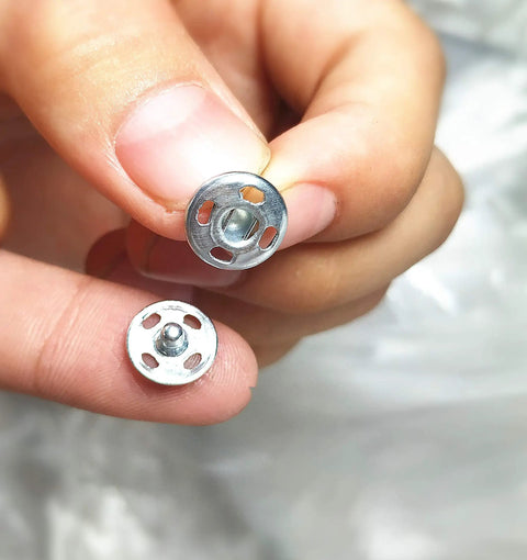 Close-up view of 120 Sets Sew On Snap Buttons Metal Fasteners For Clothing Repair And DIY Sewing 8mm 10mm 13mm Sizes Stainless Steel Rust Resistant.