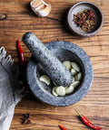 Granite Mortar And Pestle Set For Grinding Spices And Herbs Like A Boss, natural stone with garlic cloves on wooden surface