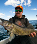 Angler holding a large walleye fish on a boat, perfect setting for using Rock Runner Slip Bouncer Weight With Quick Change Sinker