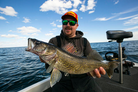 Angler holding a large walleye fish on a boat, perfect setting for using Rock Runner Slip Bouncer Weight With Quick Change Sinker