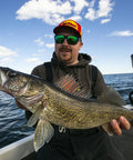 Angler on boat holding large fish, using Rock Runner Slip Bouncer Weight With Quick Change Precision Sinker For Walleye Trolling In Super Glo Wonderbread Color Three Quarters Ounce Designed To Glide Over Snags And Cut Through Cover While Delivering Precise Quick Adjustments.