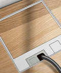 Slick Silver Recessed Floor Electrical Outlet Kit With Built In Sealing Loop For Tile And Marble Floors Tough As Nails Stainless Steel Build No Stress Lift Up Cover 2 Prong 6 Hole Design installed in wood flooring with cable plugged in.