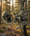 Brush Whisker Biscuit Arrow Rest with nylon bristle design on a camouflage bow for smooth arrow flight, hunting in forest setting.