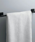 18 Inch Matte Black Towel Bar For Bathroom And Kitchen Corrosion Resistant Towel Rack That Promotes Airflow For Faster Towels Drying And A Dope Modern Home Look holding a white towel