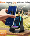 Induction Phone Stand Speaker With Colorful Lights And 3500mAh Battery Portable Hands Free Amplifier For iPhone iPad Android Samsung No Bluetooth Hassle Required on an outdoor table with a phone playing music, family in background.
