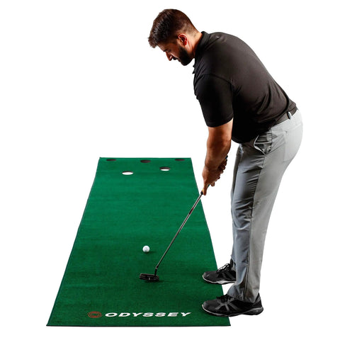 Man practicing putts on Odyssey 10 Foot Indoor Putting Green Mat For Home Or Office Practice With Realistic Surface And Extended Length