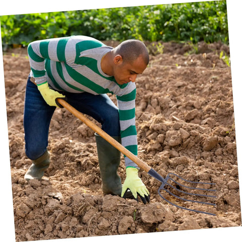 Person using Handheld Manure Fork With Solid Prongs For Grass And Garden Cleanup Durable Iron Pitch Fork For Farm And Yard Work.
