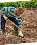Person using versatile handheld manure fork for lawn garden and farm use, five prong pitch fork for easy grass cleanup.