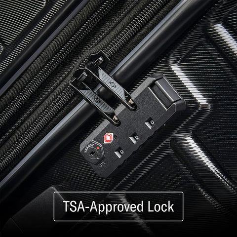 Hard-shell luggage close-up with TSA-approved lock on black surface