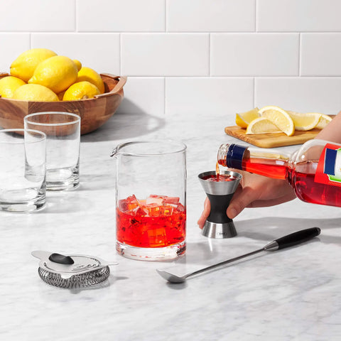 Using Stainless Steel Two Sided Jigger With Flip Measurements, Soft Non Slip Grip to pour drink into mixing glass on counter.