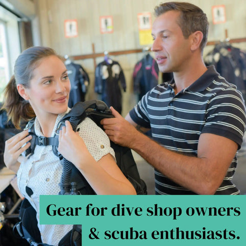 Man assisting woman with scuba gear in dive shop setting, showcasing equipment for dive shop owners and scuba enthusiasts.