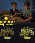 Two boys enjoying Lit 3D Monster Truck Night Light For Kids With 16 Color Changing LEDs Car Shaped Acrylic Lamp For Desk Bedroom Decor Perfect For Sleep Time Stories And Birthday Gifts glowing in the dark.