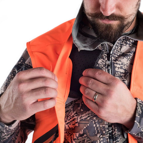 Killer Blaze Orange Ballistic Vest For Men High Visibility Hunting Gear With Water Repellent Finish shown with hands adjusting pocket.