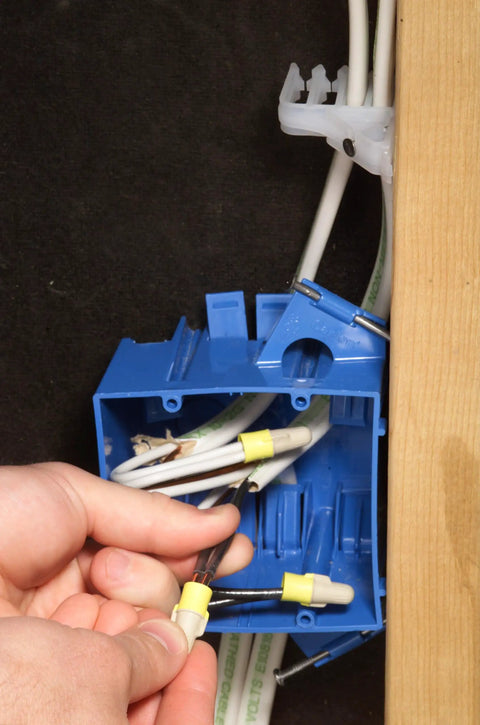 Hands using Pro Grade Dual Color Tan Yellow Wire Connector Jug Of 500, Twist On, T Y Jug for securing wires in junction box.