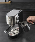 Semi Automatic Espresso Coffee Maker With Built In Steam Wand And High Pressure Pump For Rich Creamy Shots with frothing pitcher in use.