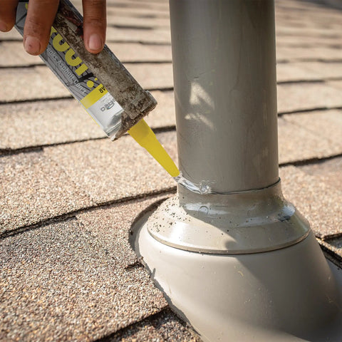 Applying All Weather Clear Roof Sealant 10.5 Oz Cartridge Pack Of Twelve to a pipe on shingles for waterproof sealing.