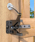 Heavy Duty Self Latching Gate Hook With Spring Release Cable on wood fence, featuring black carbon steel latch and spring mechanism.
