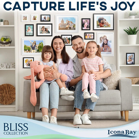 Family sitting on a sofa in a living room with a gallery of photos in sleek black 5x7 picture frames from the Bliss Collection on the wall.