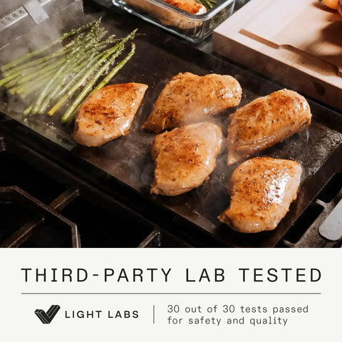 Made In Professional Carbon Steel Griddle With Cast Iron Grill Press, Giant Hibachi Style Plancha Combo For Indoor Outdoor Cooking, Induction Compatible Heavy Duty Flat Top Pan Up To 1200 Degrees Fahrenheit grilling chicken and asparagus on a flat top grill.