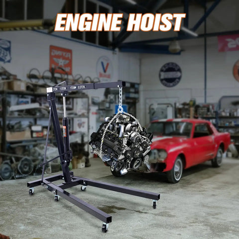 Rock Solid 2 Ton Folding Engine Hoist Cherry Picker Shop Crane Built For Hardcore Garage Swaps Featuring Hella Beefy Steel Frame And 4000 Lb Capacity lifting engine in workshop.