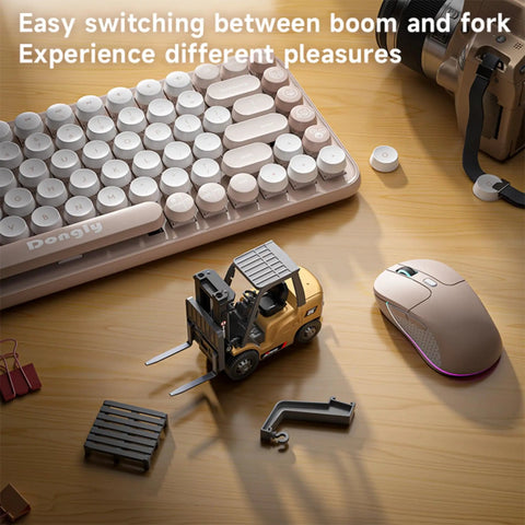 One Sixty Fourth Scale Alloy RC Forklift Toy With Lights And Sounds on a wooden table next to keyboard and mouse, with crane accessory