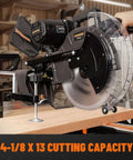 DOVAMAN 12-inch dual-bevel sliding miter saw on a workbench with clear blade guard cutting a wooden board