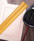 Portable Yellow Poster Tube With Paper Material Round Shape For Travel And Art Supplies next to calligraphy brush and paper