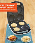 Imusa 4 Slot Electric Arepa Maker, 1200 Watt Nonstick Griddle For Fluffy Corn Cakes shown baking four corn cakes.