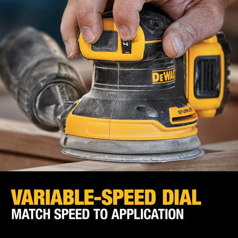 Hand adjusting speed dial on 20V Max Brushless Random Orbital Sander Kit With Variable Speed 8,000 To 12,000 OPM on wood surface.