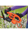 Using Powerful 3.0 Amp Electric Hedge Trimmer With 16 Inch Blade for shaping plants in garden, includes cord retention feature