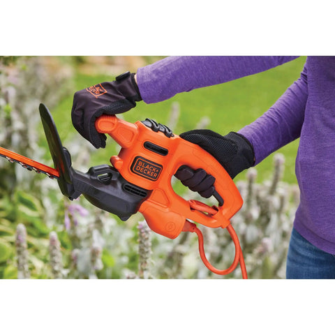 Using Powerful 3.0 Amp Electric Hedge Trimmer With 16 Inch Blade for shaping plants in garden, includes cord retention feature