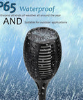 Close-up of Two Pack 33 Inch Solar Tiki Torches With 96 LED Flickering Flame Waterproof Outdoor Lights showing waterproof feature in rain.