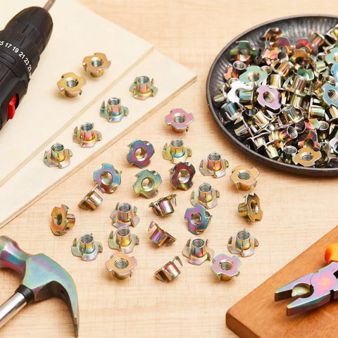 Three Eighths Inch T Nuts Sixteen Thread Four Pronged Tee Nuts Zinc Plated Steel Corrosion Resistant Seven Sixteenths Inch Barrel Length Iridescent Zinc Finish Beefy 300 Pack For Rock Climbing Holds Wood And Cabinetry - assorted T-nuts on table with drill and hammer