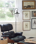 58 Inch Industrial Nautical Floor Lamp With Hanging Cage Shade, Brushed Pewter Finish beside leather chair in living room